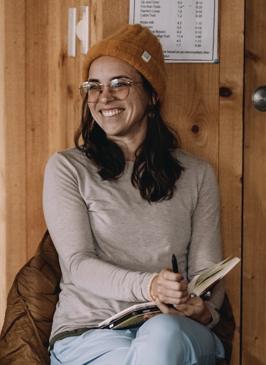 the artist smiling with their notebook open
