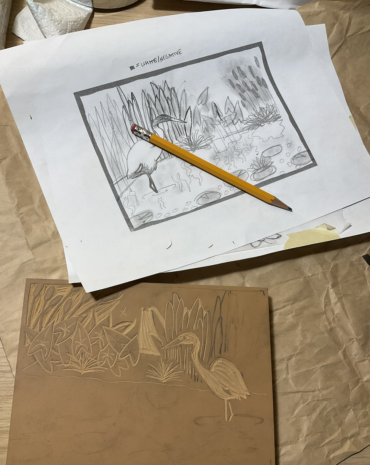 original sketch of pond design alongside partially carved linoleum block